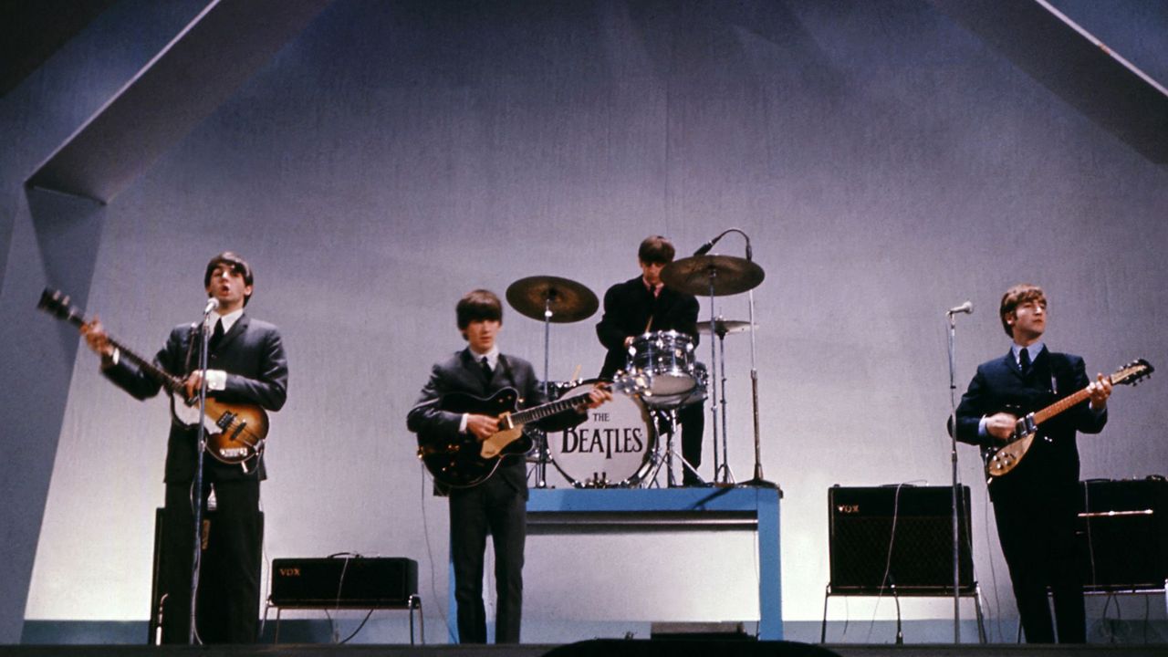The Beatles (dari kiri ke kanan), Paul McCartney (memainkan bass yang dicuri), George Harrison, Ringo Starr, dan John Lennon tampil dalam sebuah konser pada tanggal 29 Juli 1965. Central Press/AFP/Getty Images