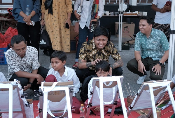 Bagus D Setyawan (baju batik) saat memperhatikan anak-anak Sekolah Dasar praktek membuat batik di Galeri Hamzah Batik Yogyakarta. (foto : dokumen pribadi)