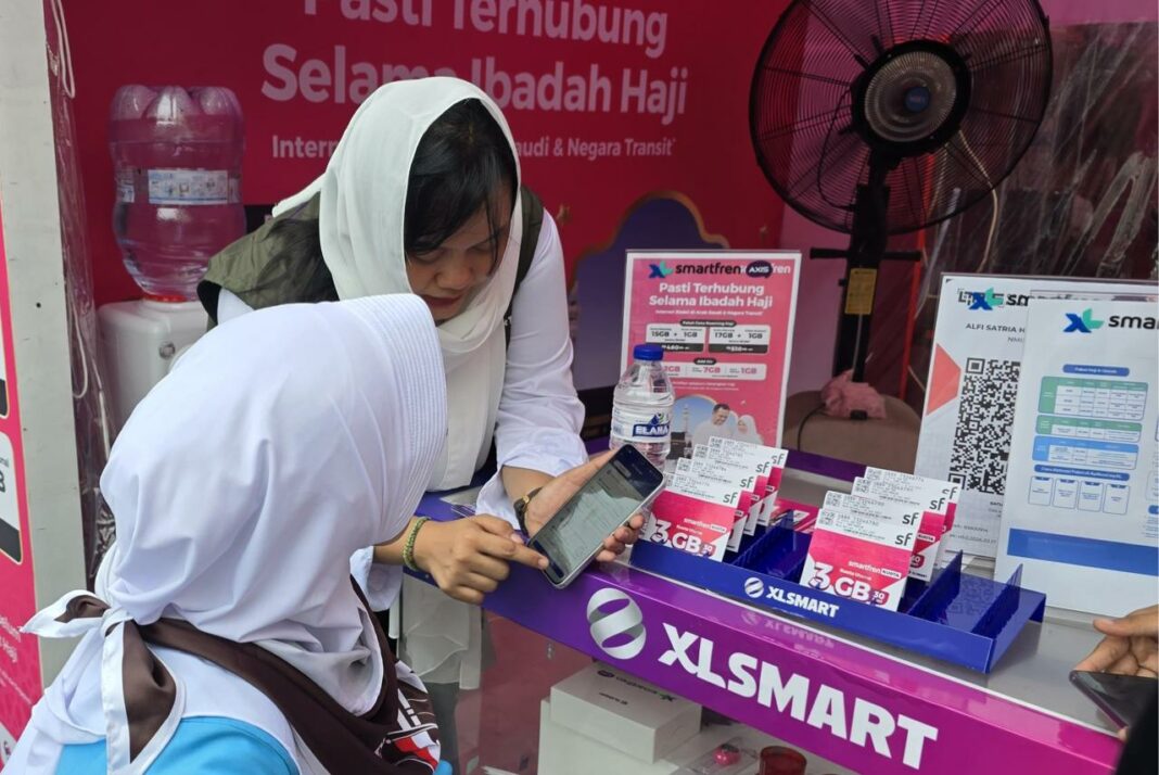 Petugas layanan pelanggan XLSMART melayani salah satu jamaah haji di Posko XLSMART Asrama Haji Bekasi, Jawa Barat, Rabu (22/4).