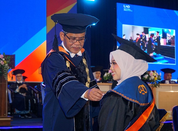 Rektor UAD, Prof Muchlas menyematkan Pin kepada wisudawati pada Periode III Tahun Akademik 2025/2026 di Gedung Jogja Expo Center (JEC) Sabtu (9/5/2026). (foto : istimewa)